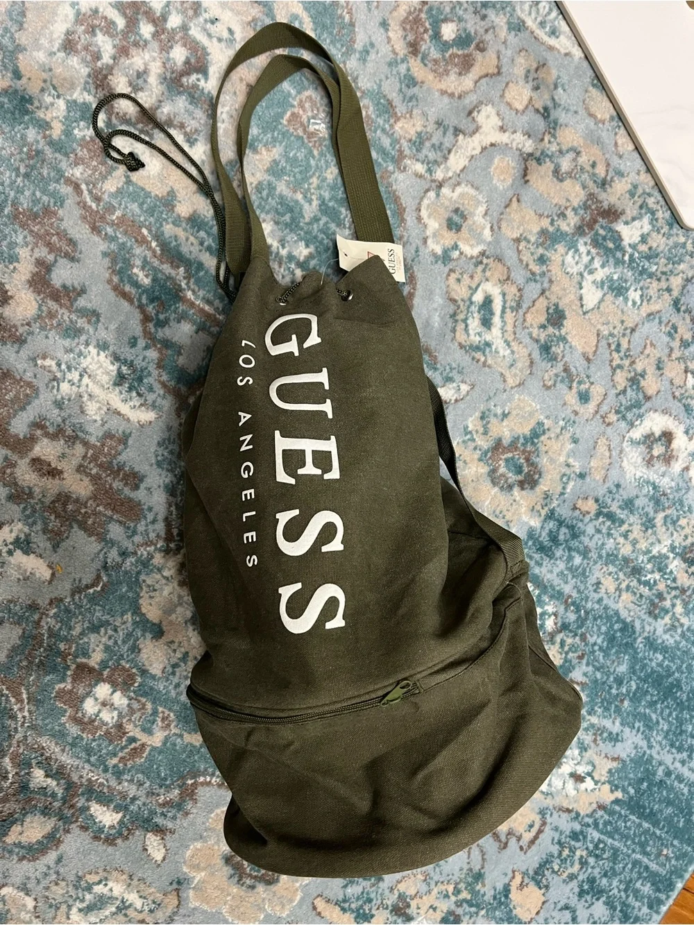 GUESS Olive Canvas Drawstring Sling Duffel Bag with zipper bottom.